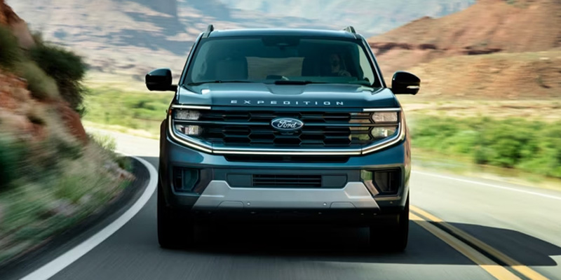 Front view of a Ford Expedition driving on a winding desert road.